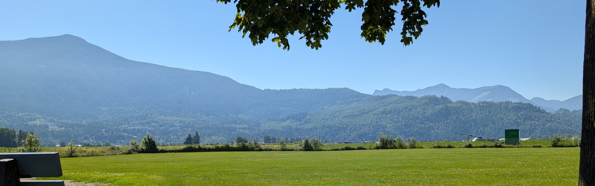 A school field with blue sky and mountains in the background