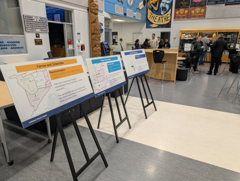 Large signs showing catchment areas are displayed on easels. 