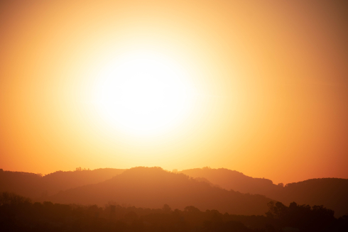 A picture of an orange sky with a bright orange sun. 