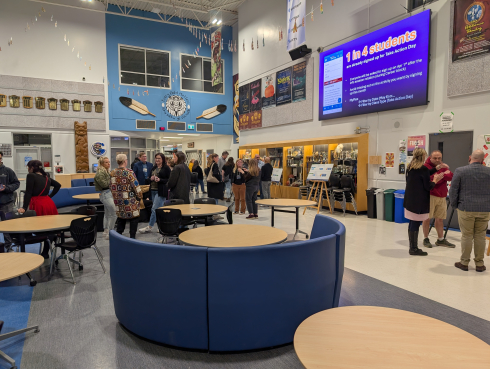 A group of people gather in a secondary school. 