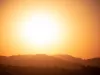 A picture of an orange sky with a bright orange sun. 