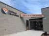 The entrance of a brown building which had a large orange, white, and black logo that reads Chilliwack School District. 